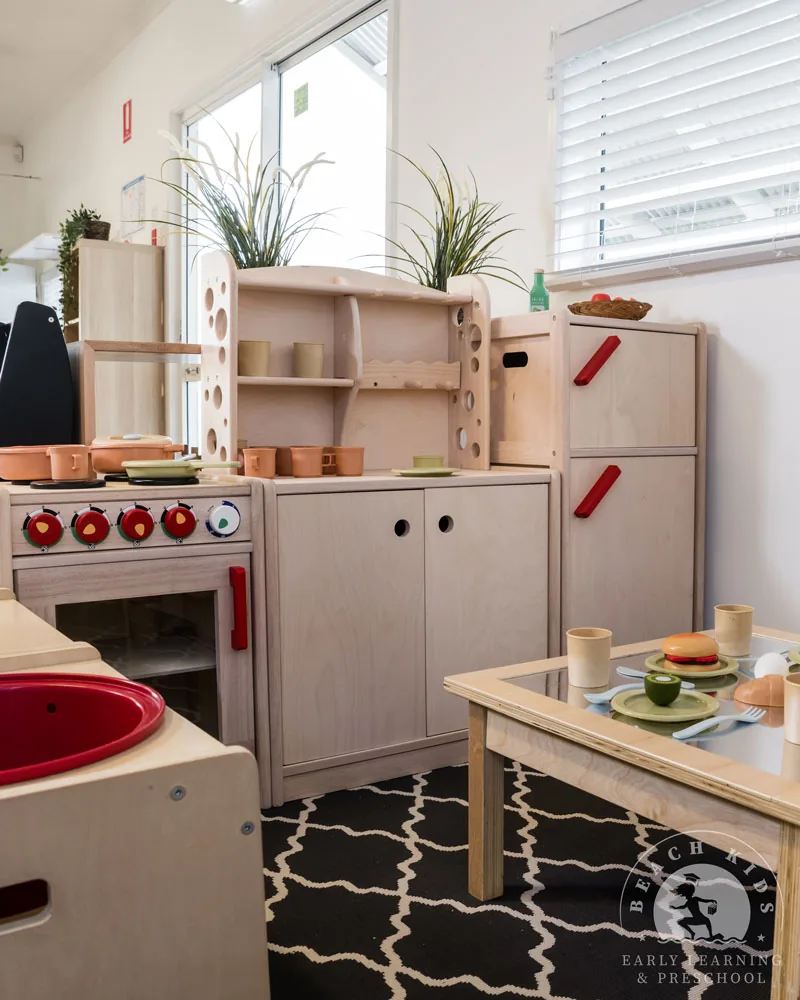 A timber play kitchen set up with play food at Beach Kids Cabarita