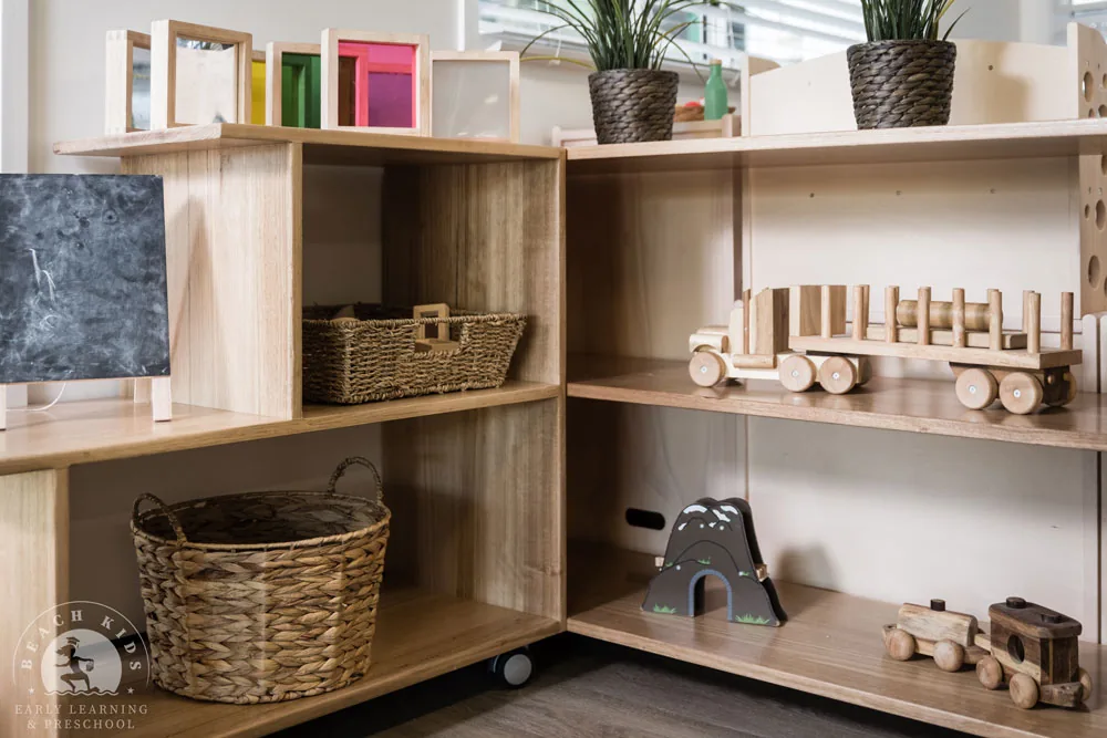 Open timber shelving with wooden vehicles and baskets in a Cabarita classroom