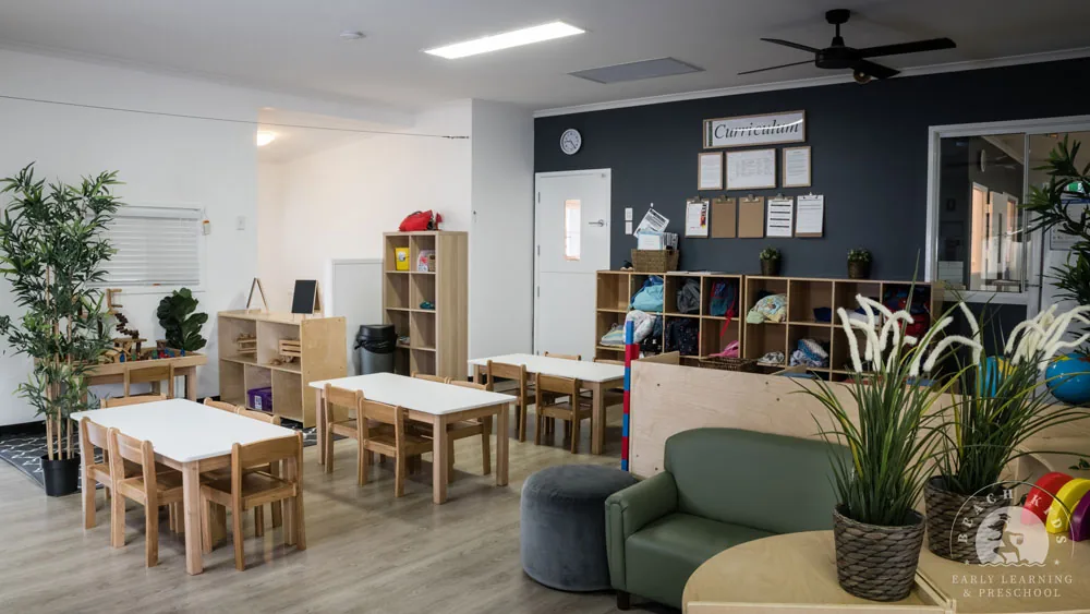 A Cabarita classroom set up with small tables, plants and open shelving