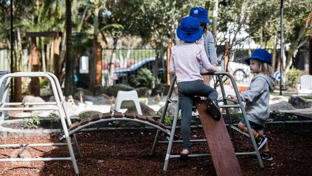 Children climbing over the arched play frame at Beach Kids Cabarita