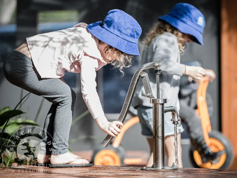 Children playing at the timber water pump at Beach Kids Cabarita