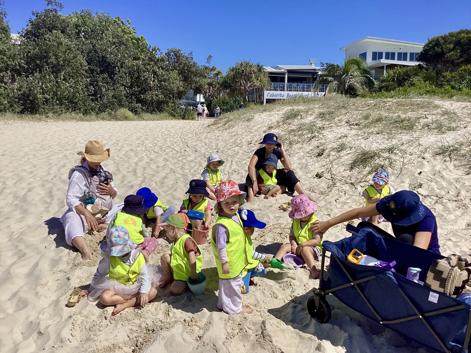A small group of Beach Kids children learning together on the sand