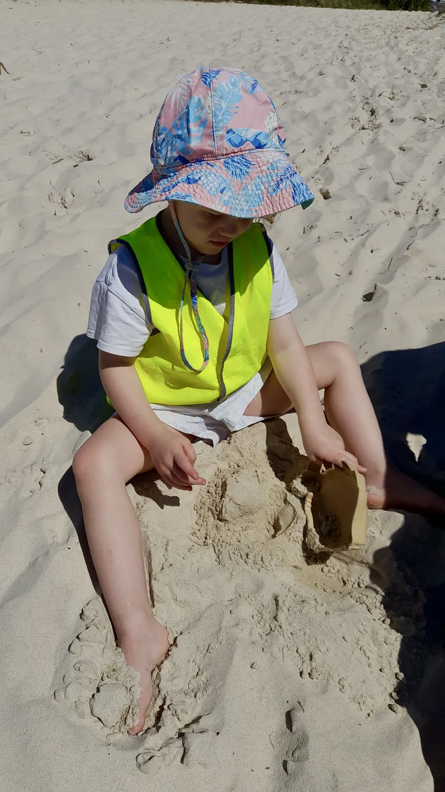 A child digging in the sand during a Beach Kinder excursion