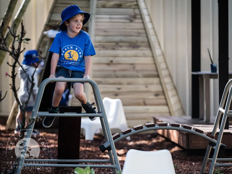 A child climbing the metal frame in the Cabarita playground